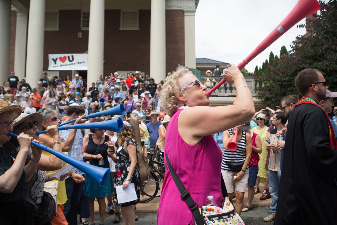 Rev. Elaine Thomas sounds a vuvuzela to lead the march on July 8.